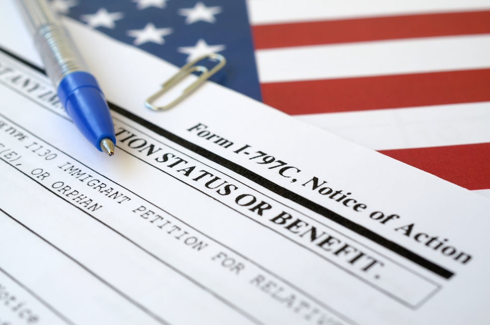 I-797C Notice of Action Blank Form Lies on United States Flag with Blue Pen from Department of Homeland Security